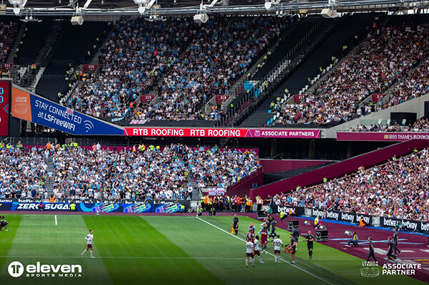RTB Roofing advertisement on stands inside West Ham London Stadium as fans gather to watch match