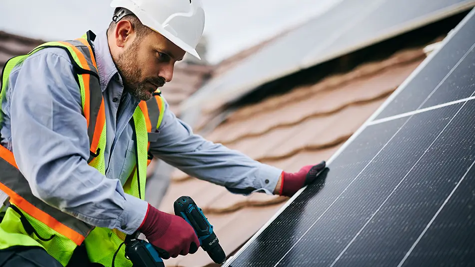 Roofer installing solar panels on roof