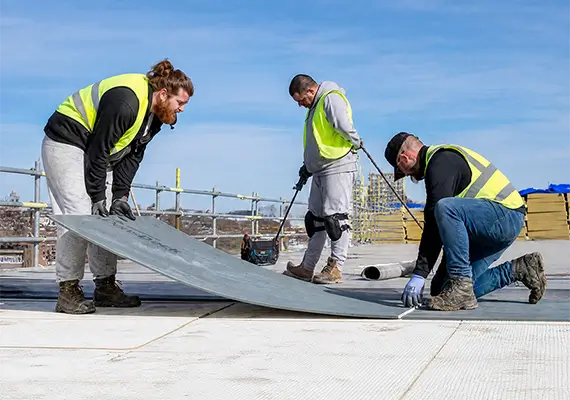 Construction workers installing DensDeck Prime Roof Boards at Bellside House