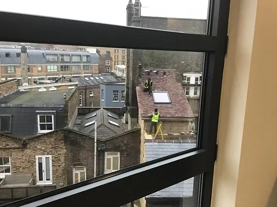 hotograph taken by member of the public of workers on roof with no fall protection measures in place