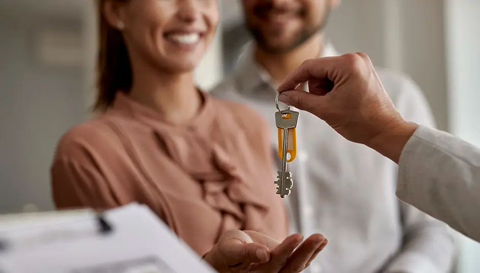 Couple collecting keys to their new home from estate agent